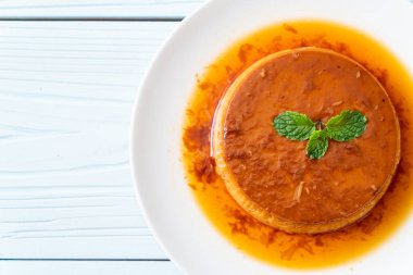 Ev yapımı karamel kremalı puding ahşap arka plan üzerinde