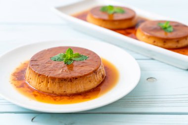 Ev yapımı karamel kremalı puding ahşap arka plan üzerinde