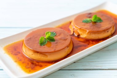 Ev yapımı karamel kremalı puding ahşap arka plan üzerinde