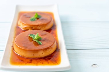 Ev yapımı karamel kremalı puding ahşap arka plan üzerinde