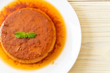 Ev yapımı karamel kremalı puding ahşap arka plan üzerinde