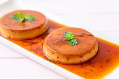 Ev yapımı karamel kremalı puding ahşap arka plan üzerinde