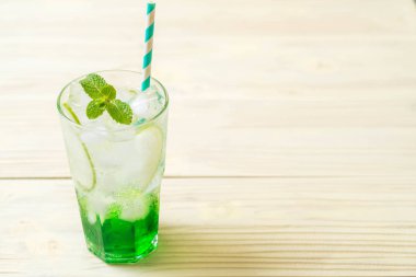 Yeşil elma soda ahşap masa üzerinde