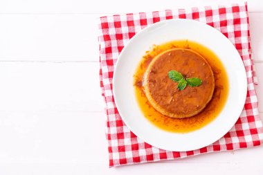 Ev yapımı karamel kremalı puding ahşap arka plan üzerinde