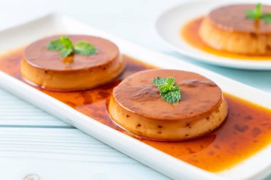 Ev yapımı karamel kremalı puding ahşap arka plan üzerinde