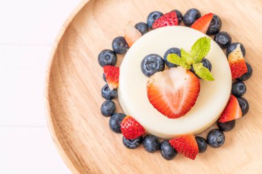 yoğurt puding plaka üzerinde bir yaban mersini ve taze çilek ile