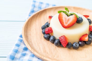yoğurt puding plaka üzerinde bir yaban mersini ve taze çilek ile
