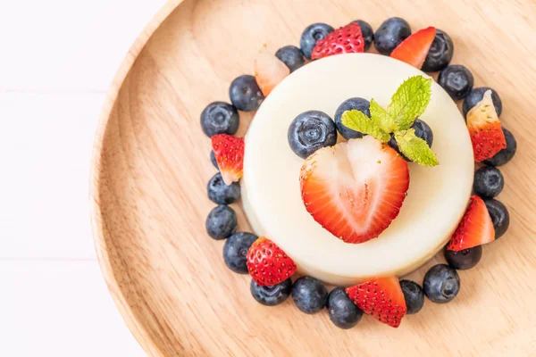 yoğurt puding plaka üzerinde bir yaban mersini ve taze çilek ile