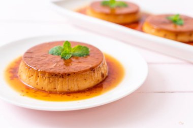 Ev yapımı karamel kremalı puding ahşap arka plan üzerinde