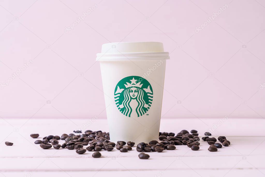BANGKOK, THAILAND - JUN 5, 2018: White coffee cup with Starbucks logo on wood background. Starbucks is the world's largest coffee house with over 20,000 stores in 61 countries.