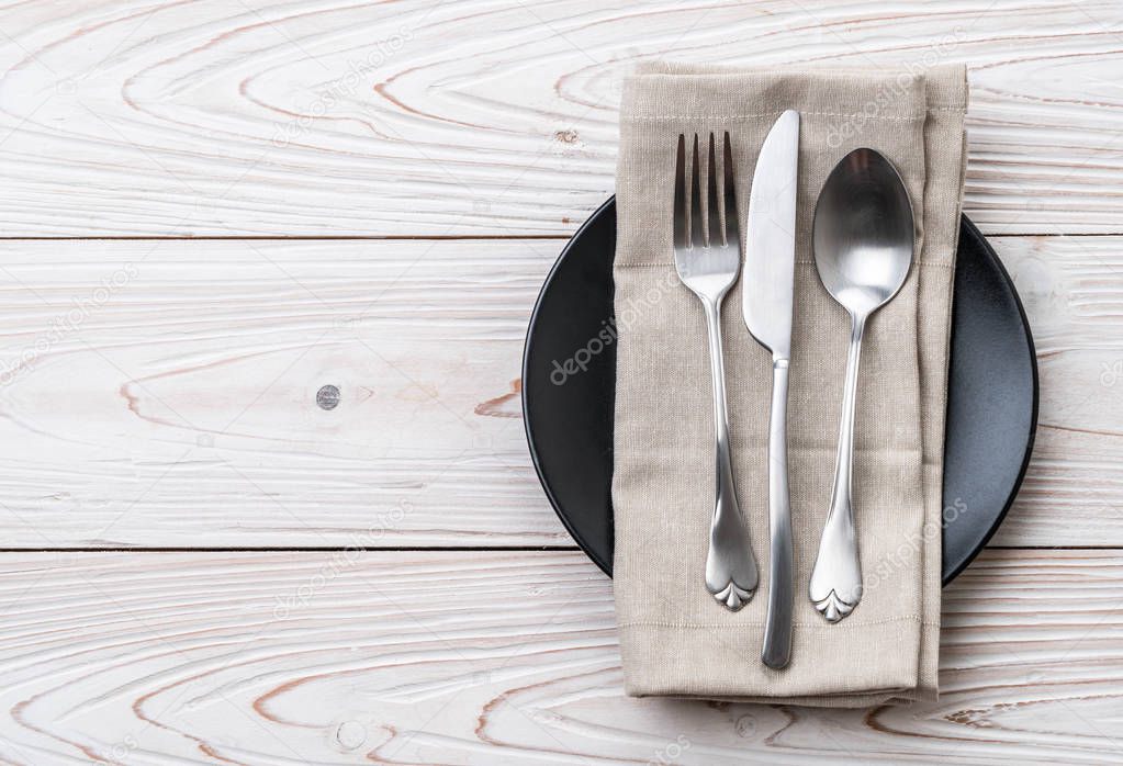 empty plate spoon fork and knife on table