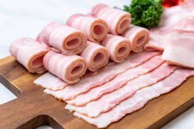 Ahşap tahta üzerinde çiğ domuz pastırma dilimlenmiş