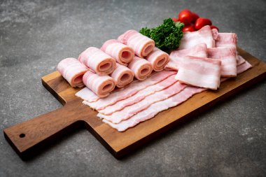 Ahşap tahta üzerinde çiğ domuz pastırma dilimlenmiş