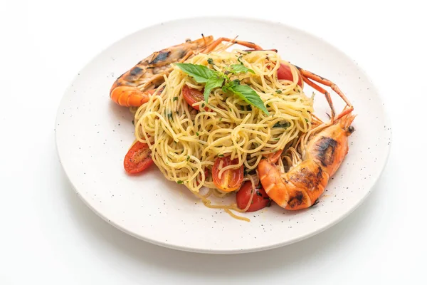 ızgara karides ve beyaz arka plan üzerinde izole domates ile tavada kızartılmış spagetti