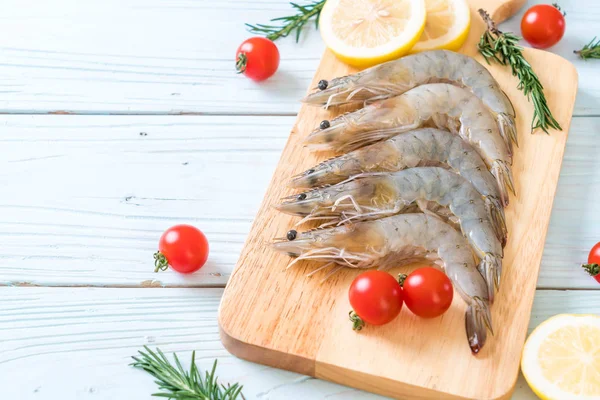 taze karides veya karides malzemelerle ahşap tahta üzerinde ham