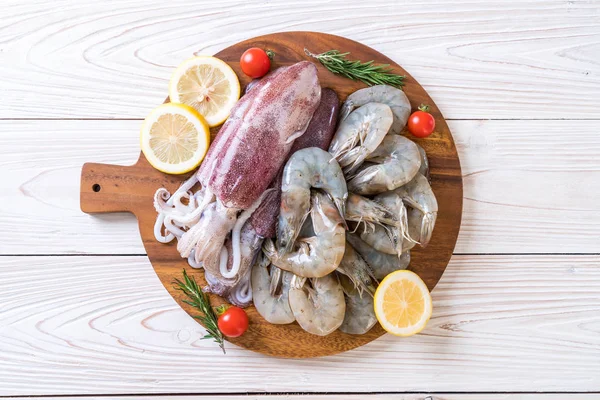 taze deniz ürünleri ham (karides, mürekkep) malzemelerle ahşap tahta üzerinde