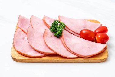 Ahşap tahta üzerinde dilimlenmiş jambon füme