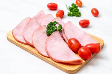 Ahşap tahta üzerinde dilimlenmiş jambon füme