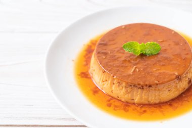 Ev yapımı karamel kremalı puding ahşap arka plan üzerinde