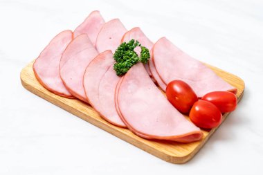 Ahşap tahta üzerinde dilimlenmiş jambon füme