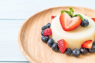 yoğurt puding plaka üzerinde bir yaban mersini ve taze çilek ile