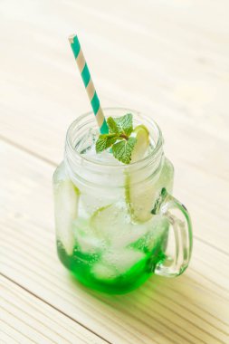 Yeşil elma soda ahşap masa üzerinde