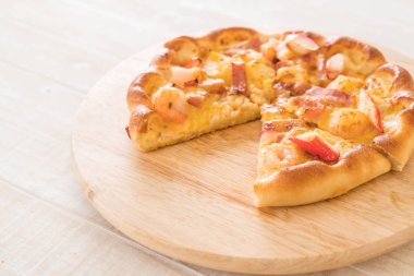 Ev yapımı hawaiian deniz ürünleri pizza ahşap plaka üzerinde