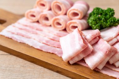 Ahşap tahta üzerinde çiğ domuz pastırma dilimlenmiş