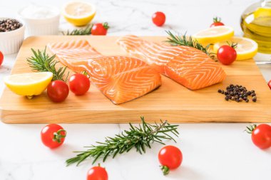 Limon domates Biberiye Biber ve tuz ahşap tahta üzerinde Çiğ somon fileto