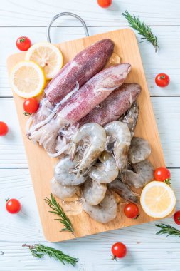 taze deniz ürünleri ham (karides, mürekkep) malzemelerle ahşap tahta üzerinde