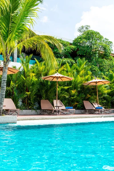 Şemsiye ve sandalye yüzme havuzunda otel ve tatil - tatil tatil kavramı çevresinde
