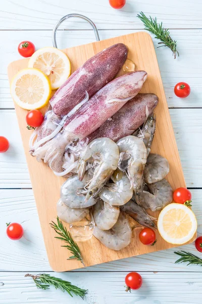 taze deniz ürünleri ham (karides, mürekkep) malzemelerle ahşap tahta üzerinde