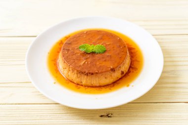 Ev yapımı karamel kremalı puding ahşap arka plan üzerinde