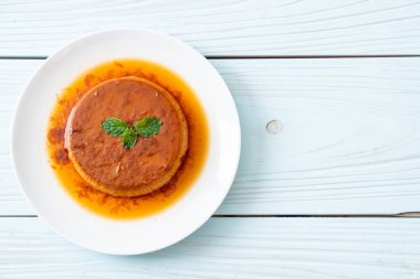 Ev yapımı karamel kremalı puding ahşap arka plan üzerinde