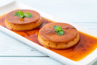 Ev yapımı karamel kremalı puding ahşap arka plan üzerinde