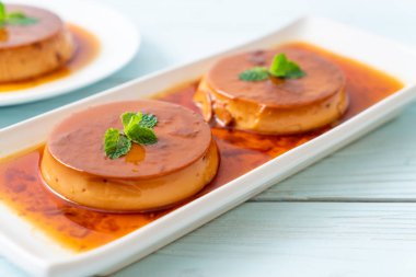 Ev yapımı karamel kremalı puding ahşap arka plan üzerinde