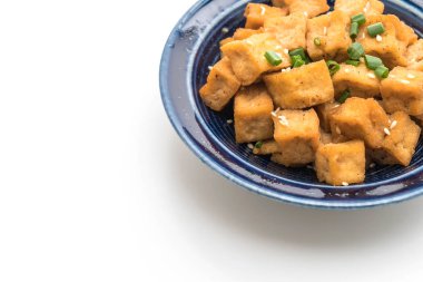 Beyaz arka plan üzerinde izole susam ile bir kase içinde kızarmış Tofu