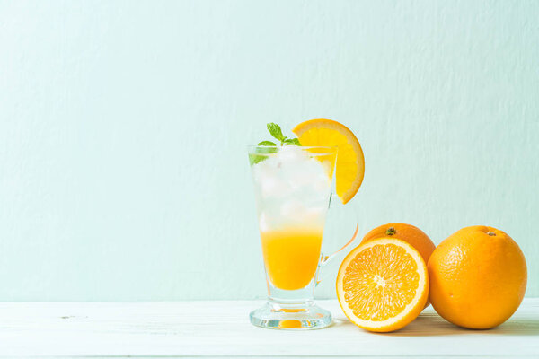 orange juice with soda on wood table