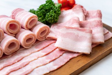 Ahşap tahta üzerinde çiğ domuz pastırma dilimlenmiş