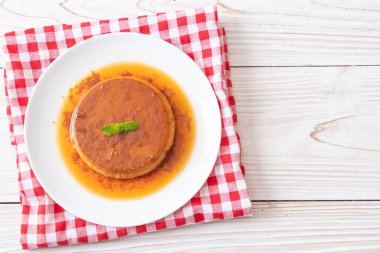 Ev yapımı karamel kremalı puding ahşap arka plan üzerinde