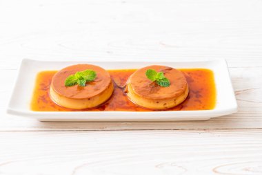 Ev yapımı karamel kremalı puding ahşap arka plan üzerinde