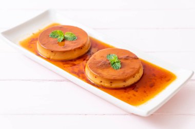 Ev yapımı karamel kremalı puding ahşap arka plan üzerinde