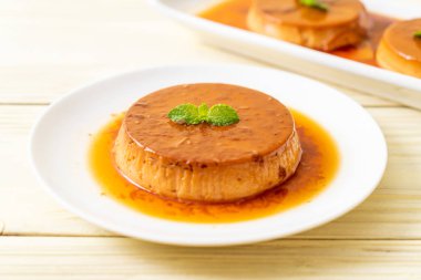 Ev yapımı karamel kremalı puding ahşap arka plan üzerinde