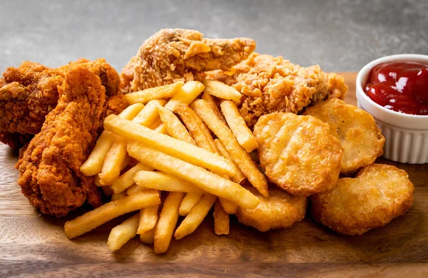 Kızarmış tavuk, patates kızartması ve nugget yemeği. Abur cubur ve sağlıksız yemek.
