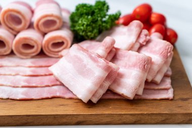 Ahşap tahta üzerinde çiğ domuz pastırma dilimlenmiş