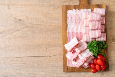 Ahşap tahta üzerinde çiğ domuz pastırma dilimlenmiş