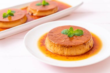 Ev yapımı karamel kremalı puding ahşap arka plan üzerinde