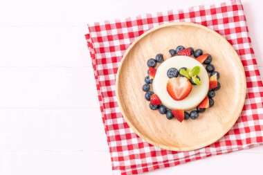 yoğurt puding plaka üzerinde bir yaban mersini ve taze çilek ile