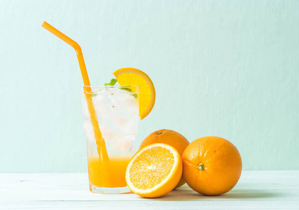 orange juice with soda on wood table