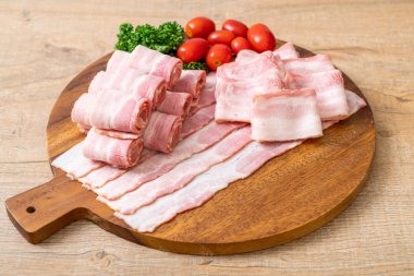 Ahşap tahta üzerinde çiğ domuz pastırma dilimlenmiş